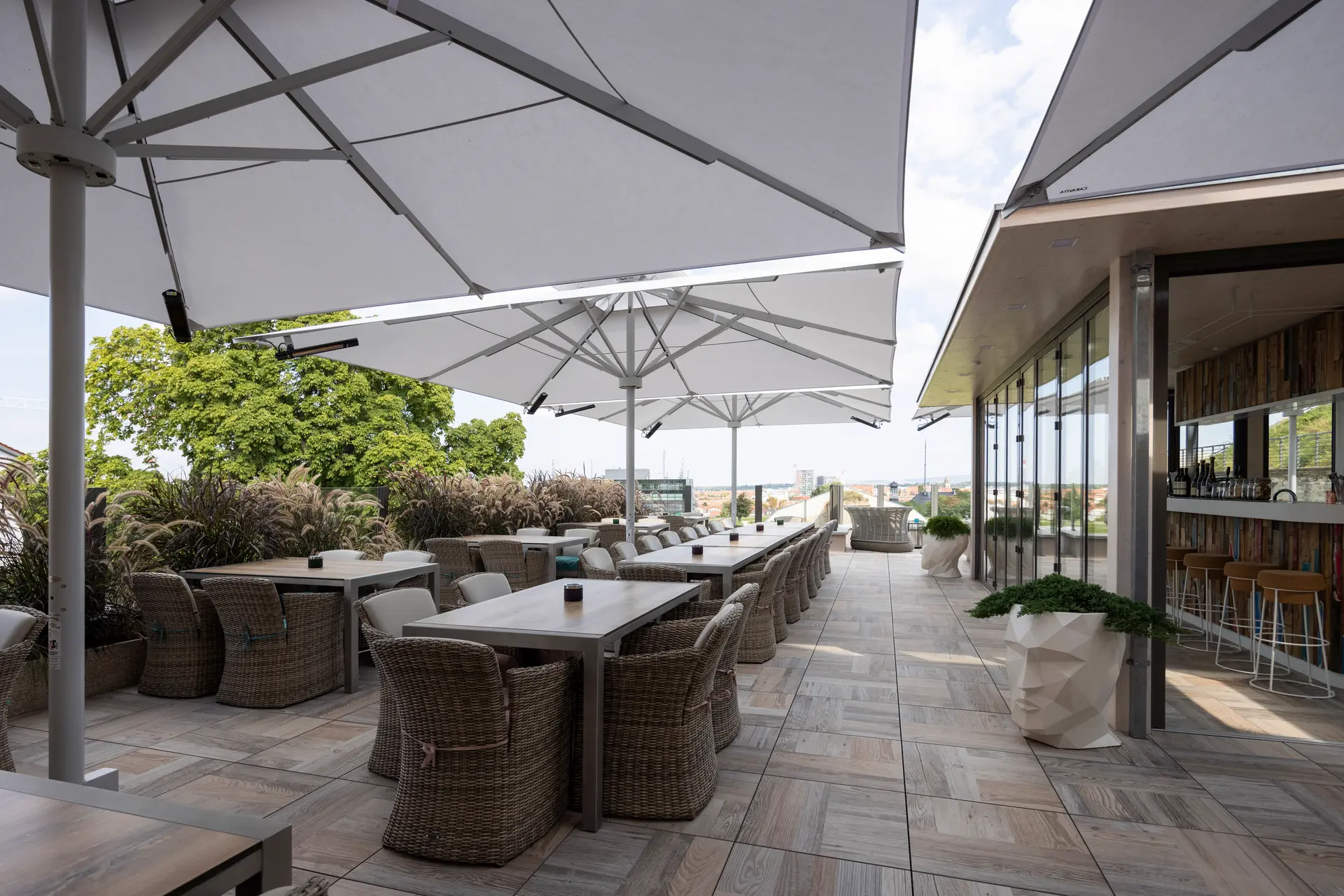 Außenbereich eines Restaurants mit flächigen Sonnenschirmen Mehrere weiße große Sonnenschirme zur Abschattung eines Außenbereichs eines Restaurants