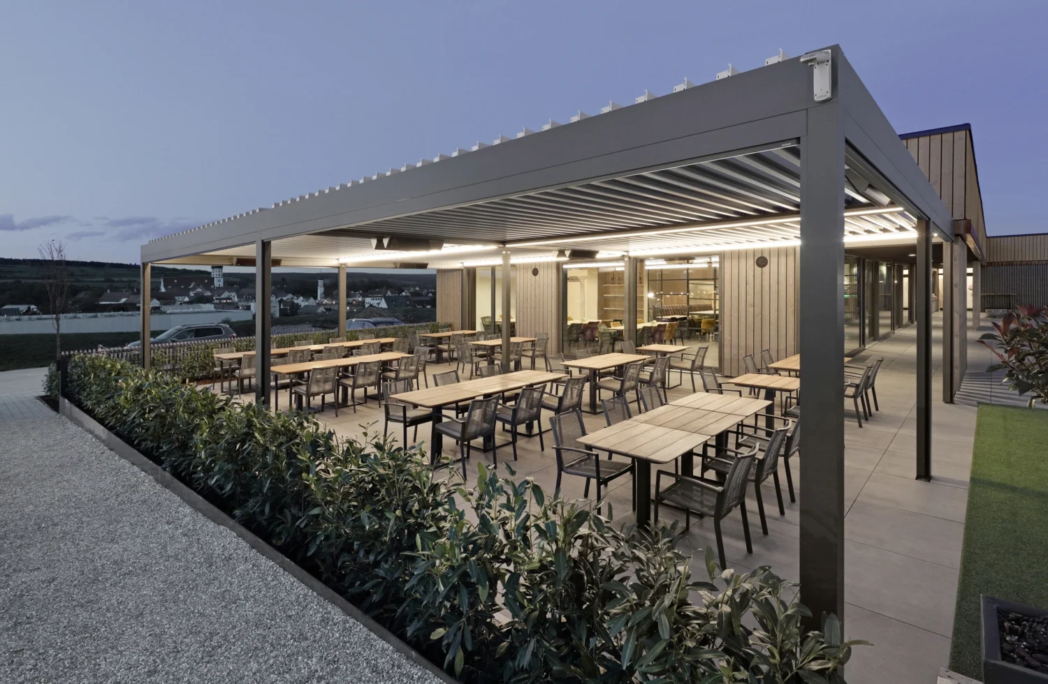 Moderne Terrasse eines Restaurants mit Blick auf Eibelstadt in der Abenddämmerung
